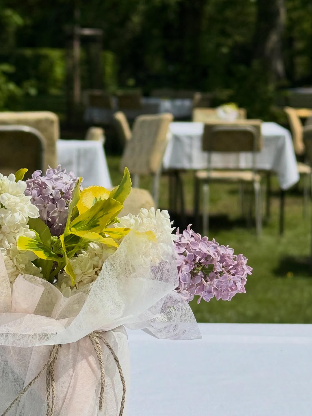 Blumenarrangement auf einer gedeckten Tafel im Park