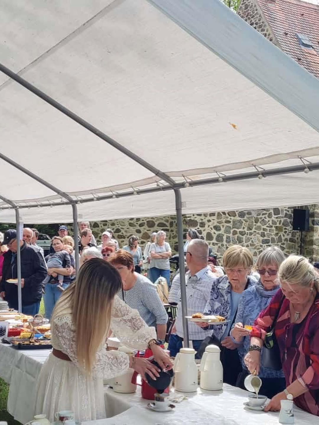 Besucherinnen und Besucher bei einer Veranstaltung unter einem Festzelt