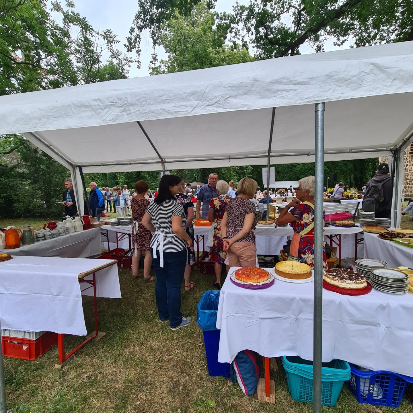 Besucherinnen und Besucher am Kuchenstand im Gutspark