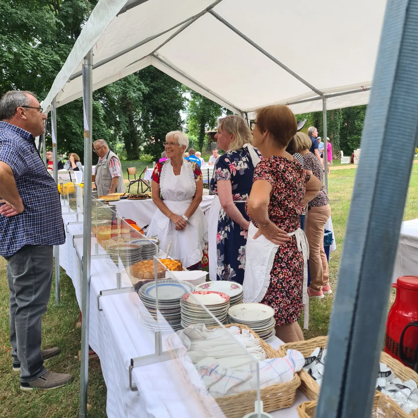 Ehrenamtliche an einem Kuchenstand unter einem Festzelt